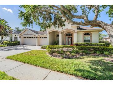 Charming one-story home with a well-manicured lawn, mature landscaping, and a spacious three-car garage at 10510 Castleford Way, Tampa, FL 33626
