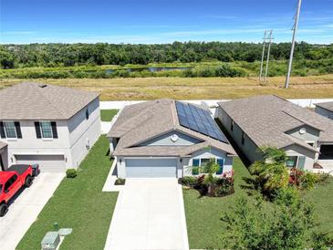 Charming single-Gathering home featuring a well-manicured lawn, solar panels, and a scenic view with a pond at 11208 Leland Groves Dr, Riverview, FL 33579