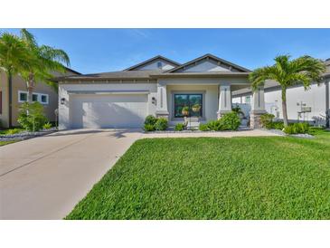 Charming single-story home features a well-manicured lawn, lush landscaping, and a two-car garage at 11407 Leland Groves Dr, Riverview, FL 33579