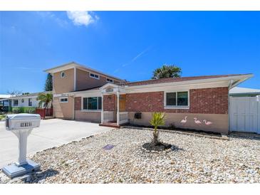 Charming two-story home showcasing a well-maintained exterior and quaint landscaping at 18102 2Nd St E, Redington Shores, FL 33708