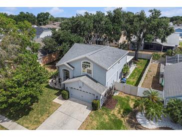 Aerial view of a blue two-story home with a well-maintained yard and a gray roof at 1830 Citrus Orchard Way, Valrico, FL 33594