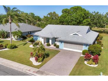 Charming single-story home with a paver driveway, attached two-car garage and mature landscaping at 1909 E View Dr, Sun City Center, FL 33573