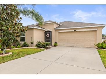 Charming single-story home features a well-maintained lawn, mature trees, and a two-car garage at 233 Cascade Bend Dr, Ruskin, FL 33570