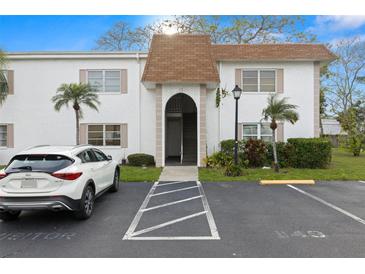 White condo building exterior with neat landscaping, parking, and brown roof at 343 S Mcmullen Booth Rd # 151, Clearwater, FL 33759