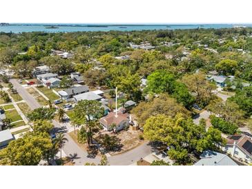 Charming single-Gathering home nestled among lush trees in a quiet residential neighborhood with water views in the distance at 1232 Sedeeva S Cir, Clearwater, FL 33755