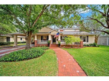 Inviting home with a charming brick pathway, lush landscaping, and a cozy front porch at 3408 W San Jose St, Tampa, FL 33629