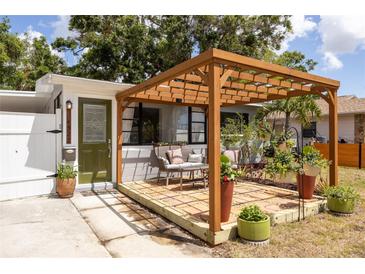 Inviting patio with pergola, stylish seating, and lush potted plants create a cozy outdoor space at 4527 24Th S Ave, St Petersburg, FL 33711