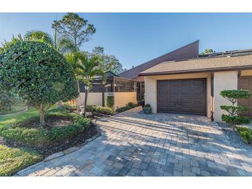 Charming home with lush landscaping and a private garage on a sunny day at 5010 Umber N Way, Tampa, FL 33624