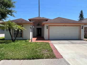 Charming single-story home with a well-manicured lawn and attached two-car garage at 8908 Southbay Dr, Tampa, FL 33615