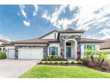 Charming single-story home showcasing a tiled roof, stone accents, and well-manicured front yard at 148 Mossy River Ct, Brandon, FL 33511