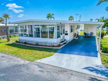 Charming single-story home featuring a covered parking area, enclosed patio, and well-maintained landscaping at 18675 Us Highway 19 N # 140, Clearwater, FL 33764