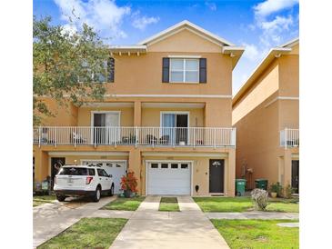 Inviting two-story townhome featuring a white balcony, attached garage, and manicured front lawn at 6823 S Kissimmee St, Tampa, FL 33616