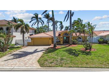 Charming home with a beautiful lawn, terracotta roof, palm trees, and a paved driveway, perfect for coastal living at 8014 12Th S Ave, St Petersburg, FL 33707