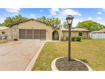 Charming single-story home featuring a well-manicured lawn, decorative stone accents, and a spacious driveway at 9069 Gaynor St, Spring Hill, FL 34608