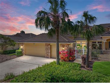 Charming single-story home featuring lush landscaping, a three-car garage, and a tiled roof at 13143 Palmilla Cir, Dade City, FL 33525