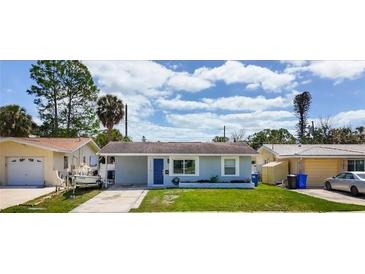 Charming single-story home with a well-maintained lawn and a lovely blue front door at 1734 Shore Acres Ne Blvd, St Petersburg, FL 33703