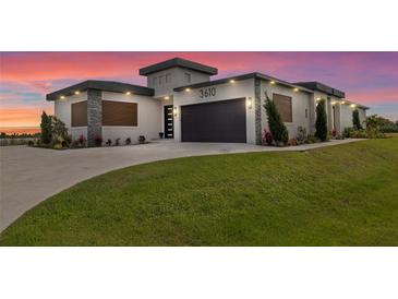 Contemporary home featuring a lush lawn, a driveway, and a stylish two-car garage at 3610 Gulf City Rd, Ruskin, FL 33570