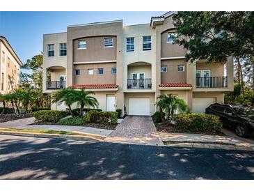 Townhouse exterior boasts a Mediterranean style, private balconies, attached garage, and vibrant landscaping at 805 100Th N Ave, St Petersburg, FL 33702