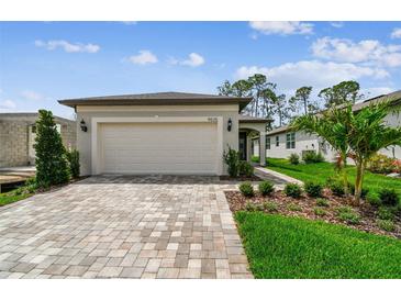 Charming single-Gathering home with a two-car garage and a beautifully paved driveway and walkway, and manicured lawn at 9535 Coastline Way, Parrish, FL 34219