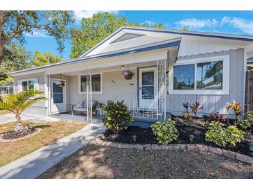 Charming home featuring a cozy front porch with stylish seating and well-maintained landscaping at 1422 Pinebrook Dr, Clearwater, FL 33755