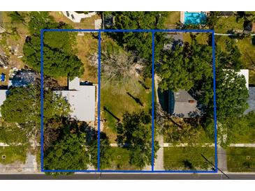 Aerial view of the property highlighting its location and surroundings, with neighboring homes and mature trees at 311 83Rd Ne Ave, St Petersburg, FL 33702