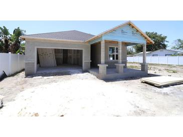 New construction features an attached garage, covered porch with columns, and a neutral color palette at 4244 11Th N Ave, St Petersburg, FL 33713