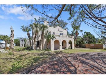 Stately home featuring arched porch, palm trees, and classic architectural detailing on a sunny day at 636 Sunset S Dr, St Petersburg, FL 33707