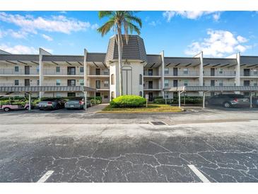 Three-story condo building with private balconies, covered parking, and a well-maintained lawn at 8765 Bardmoor Blvd # 107, Seminole, FL 33777