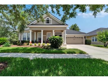 Charming single-story home with manicured lawn and a welcoming front porch with white columns at 20537 Lace Cascade Rd, Land O Lakes, FL 34637