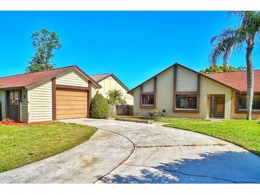Inviting home featuring a well-manicured lawn, a spacious driveway, and an attached two-car garage at 2459 Bay Berry Dr, Clearwater, FL 33763