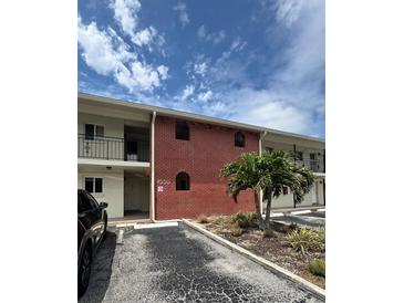 Building exterior showing brick facade, balconies, and landscaping with a small palm tree at 4550 Overlook Ne Dr # 156, St Petersburg, FL 33703