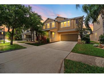 Two-story home features a front lawn, a two-car garage, and a driveway at 7029 Dowling Mill Cir, Tampa, FL 33625