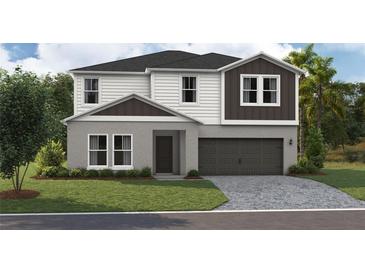 Charming two-story home featuring a two-car garage, landscaped yard, and modern architectural details at 37061 Sagemoor Dr, Zephyrhills, FL 33541