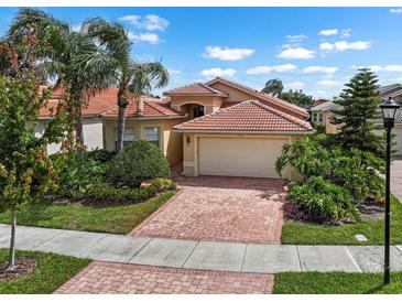 Beautiful single Gathering home with a tile roof, two-car garage and a red brick driveway at 4917 Sandy Brook Crk, Wimauma, FL 33598