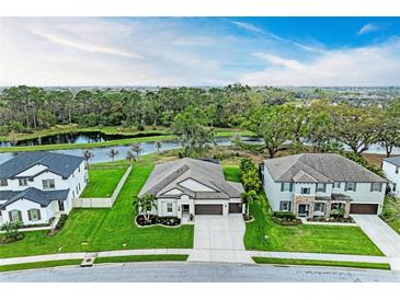 Stunning aerial view of a modern home with a lake view and well-manicured lawn at 13034 Bliss Loop, Bradenton, FL 34211