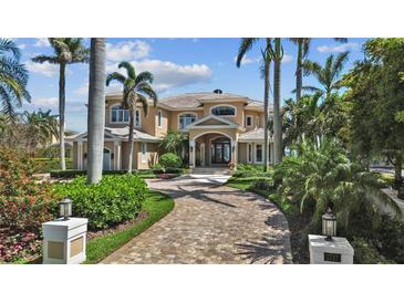 Stately two-story home featuring a brick driveway, grand entrance, lush landscaping, and mature palm trees at 1737 Brightwaters Ne Blvd, St Petersburg, FL 33704