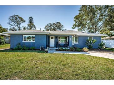 Charming one story home with a lush lawn, classic curb appeal and rocking chairs at 1965 Allard Dr, Clearwater, FL 33763