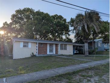 Charming single-story home with a cozy front porch, attached carport, and mature trees at 4581 Deltona Blvd, Spring Hill, FL 34606