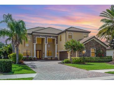 Stately two-story home with lush landscaping, brick driveway, and grand entrance with impressive columns at 5656 Cloverleaf Run, Bradenton, FL 34211