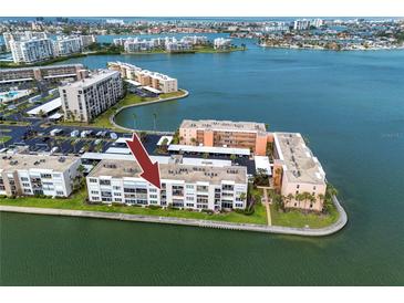 Aerial view of a waterfront condo with a parking lot and beautiful water views, perfect for coastal living at 7645 Sun Island S Dr # 304, South Pasadena, FL 33707