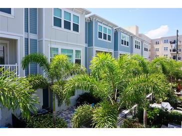 Charming townhome showcasing a lovely facade and complemented by lush, mature palms at 813 Burlington N Ave, St Petersburg, FL 33701