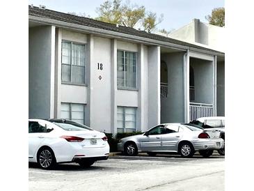 Exterior view of the condo building featuring covered entries and ample parking at 2625 State Road 590 # 1822, Clearwater, FL 33759