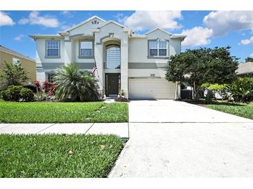 Charming two-story home featuring lush landscaping and a well-manicured lawn at 3243 Ashmonte Dr, Land O Lakes, FL 34638