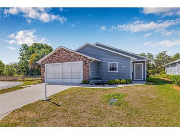 Charming single Gathering home features a brick facade, two-car garage, and well-maintained landscaping at 37434 Derbyshire Dr, Zephyrhills, FL 33542