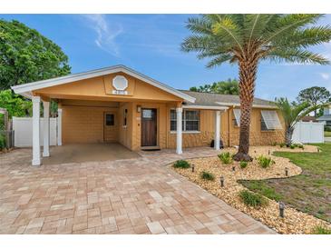 Charming single Gathering home features a brick driveway, covered front porch, and well-manicured landscaping at 4815 Plantation Dr, Tampa, FL 33615