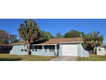 Charming single-story home featuring an attached garage and welcoming front porch at 1007 Greenleaf Way, Tarpon Springs, FL 34689