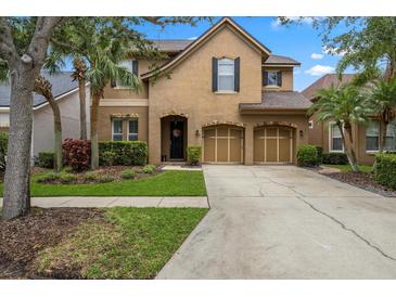 Charming two-story home with a well-manicured lawn, mature trees, and a two-car garage at 11607 Meridian Point Dr, Tampa, FL 33626