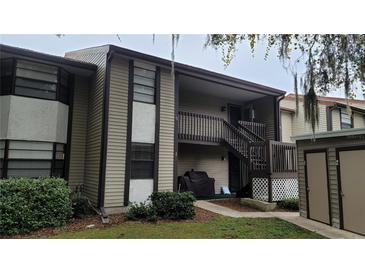 Two-story condo featuring covered entry, brown wood accents, and well maintained landscaping at 12041 Environmental Dr # 6, New Port Richey, FL 34654