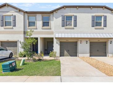 Charming townhome exterior with a well-maintained lawn and a private garage at 14323 Easy Goer St, Ruskin, FL 33573