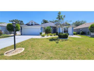 Charming single-story home boasts a well-manicured lawn, front-entry garage, and delightful landscaping at 2113 E Del Webb Blvd, Sun City Center, FL 33573